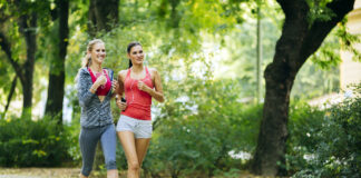 Dwie młode kobiety biegające po parku